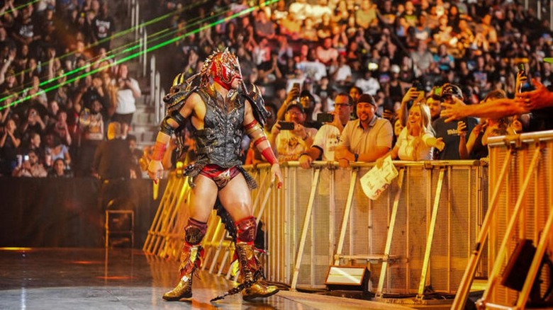 Dragon Lee stands on the stage and looks toward the ring ahead of a match on 
