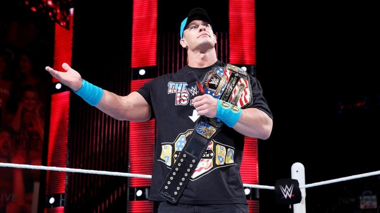 John Cena cutting a promo while posing with the WWE United States Championship.