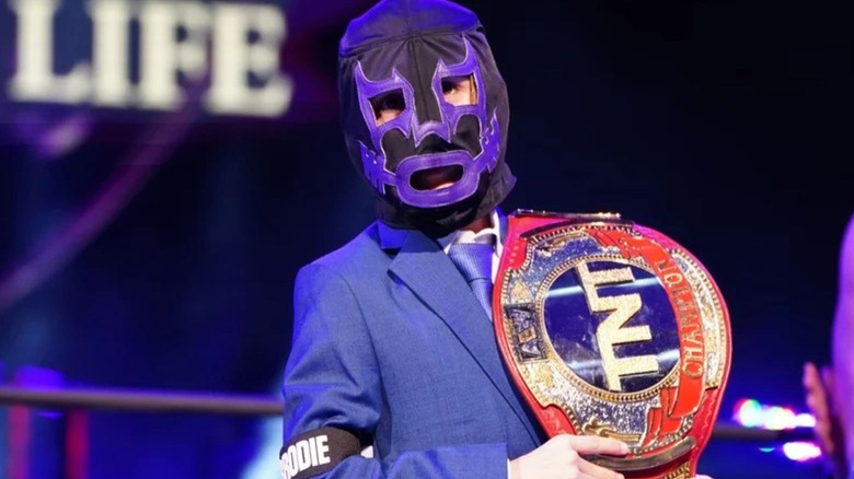 Brodie Lee Jr., in his Negative One mask, hold the TNT Championship during a tribute to his late father in AEW.