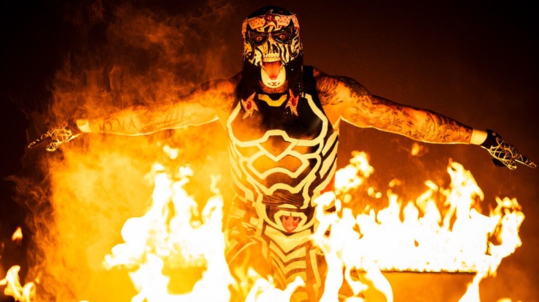 Penta emerging through flames for a photoshoot with WWE.