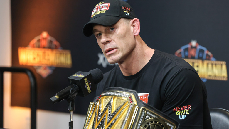 John Cena sitting in front of a microphone