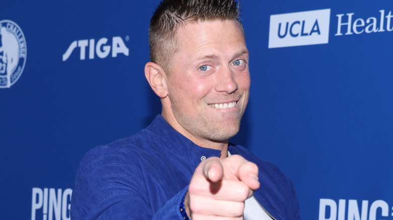 The Miz points towards the camera during a charity event