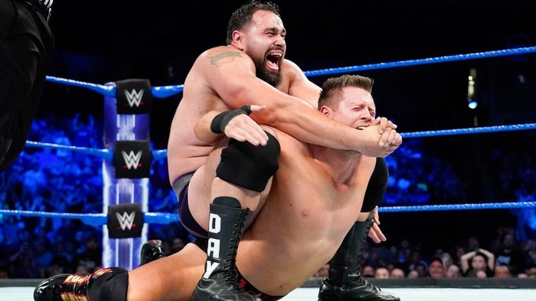 Rusev locking The Miz into The Accolade during a clash between the two of them on 