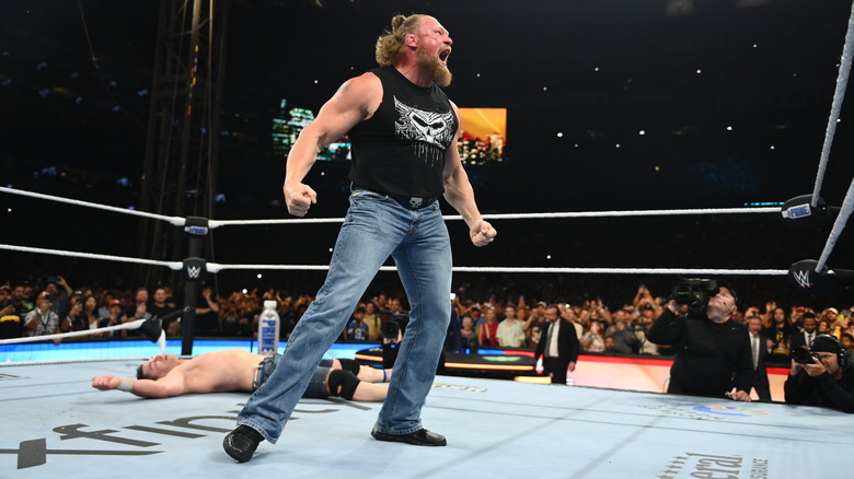 Brock Lesnar screams in the ring above a fallen John Cena at WWE SummerSlam