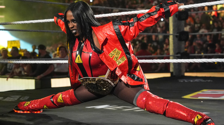 Naomi leans against the bottom and middle ropes during her entrance as the WWE Women's World Champion.