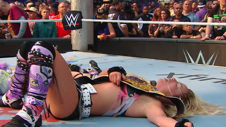 Liv Morgan lies on the mat holding her title at WWE SummerSlam
