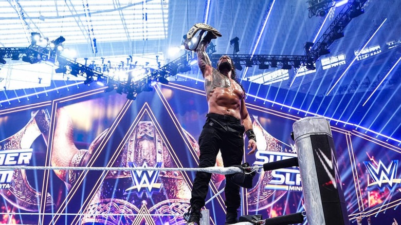 World Heavyweight Champion Roman Reigns poses on the turnbuckle, title raised, following his win over Seth Rollins at WWE SummerSlam 2026.