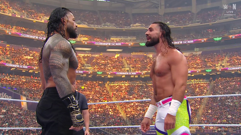 Reigns and Rollins staring down one another in the ring