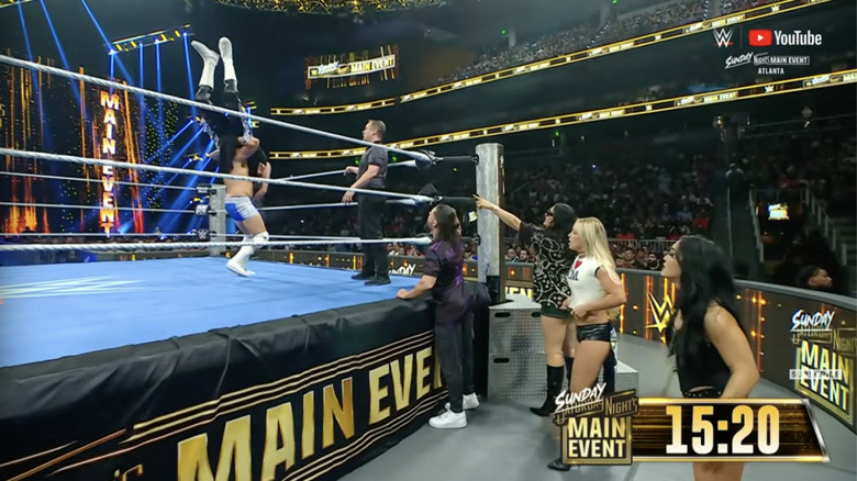 Hendry with Dominik in a delayed vertical suplex position as Judgment Day watches