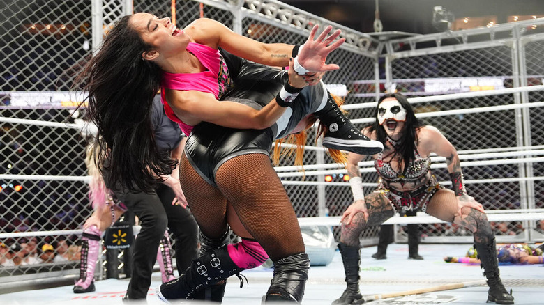 AJ Lee taps out Becky Lynch while Rhea Ripley looks on at WWE Survivor Series