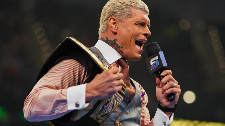 Cody Rhodes barks into the microphone as his Undisputed Universal WWE Championship hangs on his shoulder.