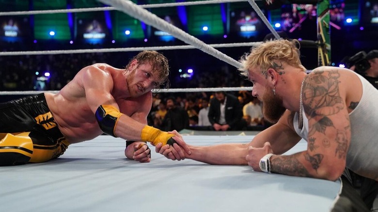 Logan Paul shakes his brother Jake's hand at ringside despite the loss against Roman Reigns at the 2022 WWE Crown Jewel event