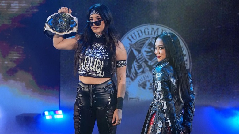 Women's Intercontinental Champion Raquel Rodriguez stands onstage alongside Roxanne Perez, title in hand, ahead of a match on 