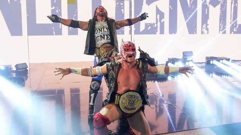 WWE World Tag Team Champions AJ Styles and Dragon Lee pose on the stage, the belts around their waists, before a match on 