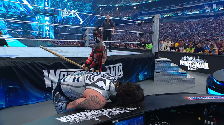 Balor about to hit Dominik with the kendo stick