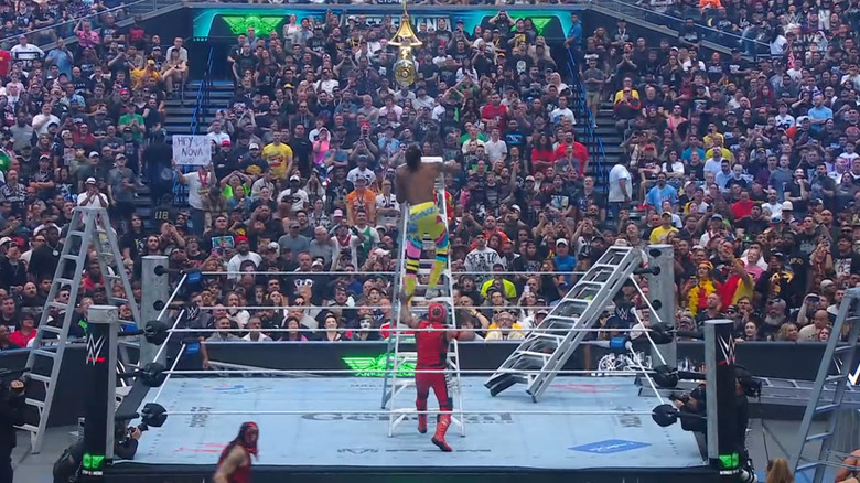 Evans and Rey in the ring as Penta is on the outside