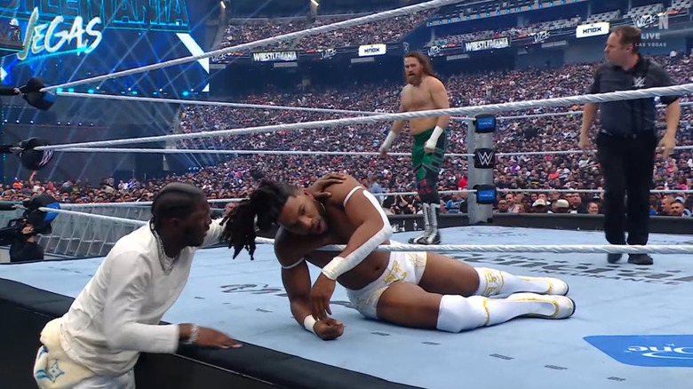 Yachty checking on Williams from the outside as Zayn stands in the ring