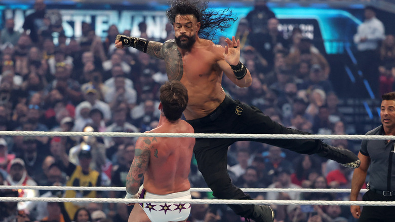Roman Reigns prepares to land a Superman Punch on CM Punk.