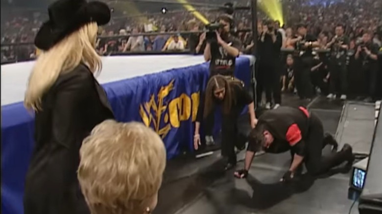 Trish Stratus and Linda McMahon look on as Stephanie McMahon checks on her father, Vince McMahon, during his street fight match against Shane McMahon at WrestleMania X-Seven.