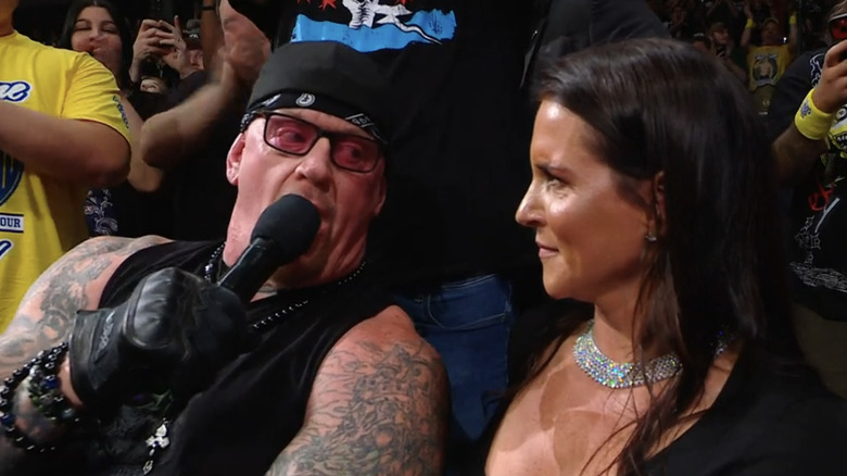 Mark Callaway, formerly known as The Undertaker, speaks to a tense Stephanie McMahon on the mic.