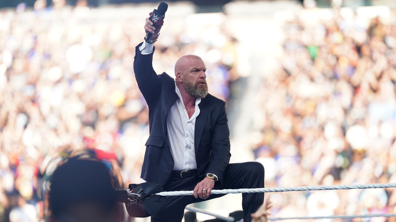 Paul Levesque holds up a microphone