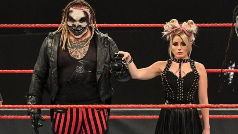 Bray Wyatt and Alexa Bliss hold hands in the middle of the ring during a segment with Retribution on an October 2020 edition of WWE programming.