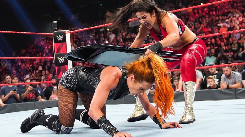 Bayley hitting Becky Lynch with a steel chair during a clash on 