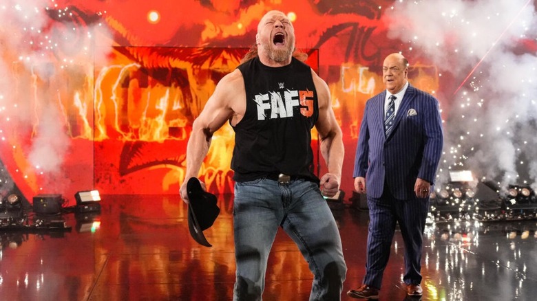 Brock Lesnar poses on stage, pyro and Paul Heyman behind him, before heading to the ring for a segment on 