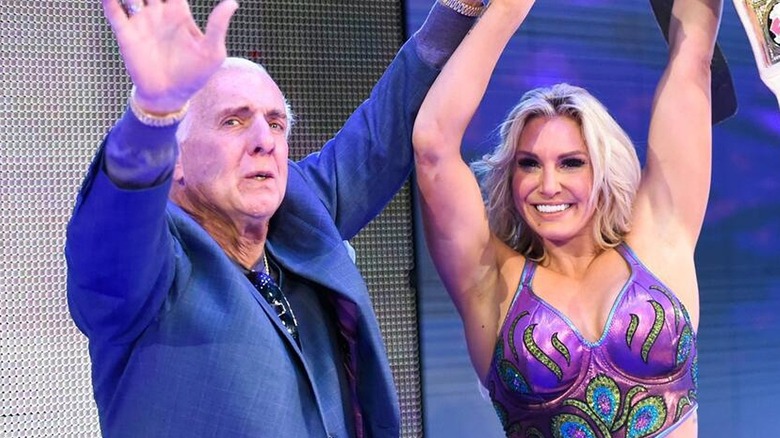 Charlotte Flair and Ric Flair celebrating after she won the WWE SmackDown Women's Championship