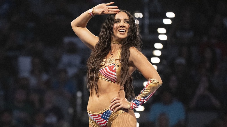 Chelsea Green at the top of the turnbuckle posing with a salute during a WWE show.