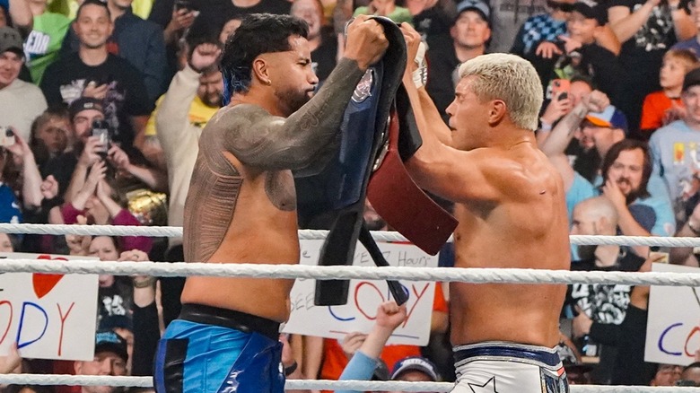 Jey Uso and Cody Rhodes clink title belts together