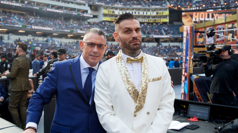 Corey Graves, unaware that Michael Cole is ready to attack him from behind