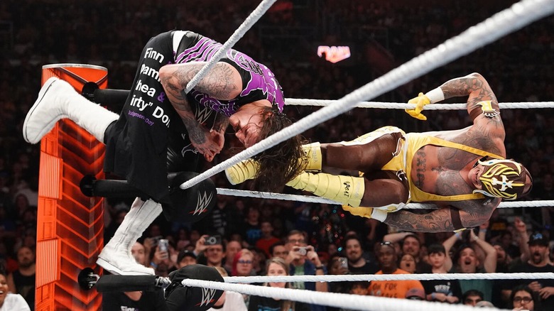 Rey Mysterio hitting Dominik Mysterio with a 619 while he hangs from the top rope.