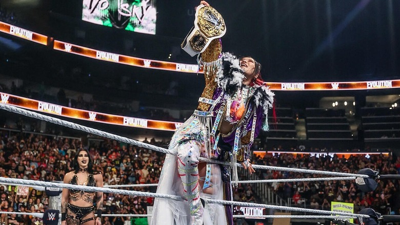 IYO SKY poses with her former WWE Women's World Championship before her title defense at Evolution II