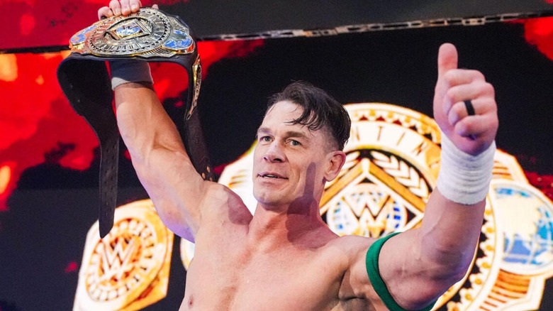 John Cena holds up the Intercontinental Championship on the stage and gives a thumbs up to the fans on an episode of 