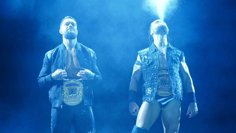 Finn Balor fixes his jacket while JD McDonagh spits water