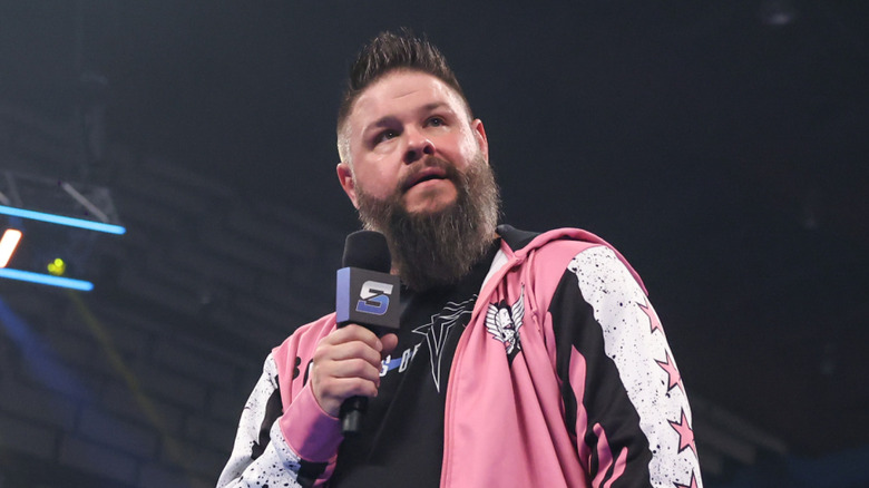 Kevin Owens cutting a promo in his pink hoodie
