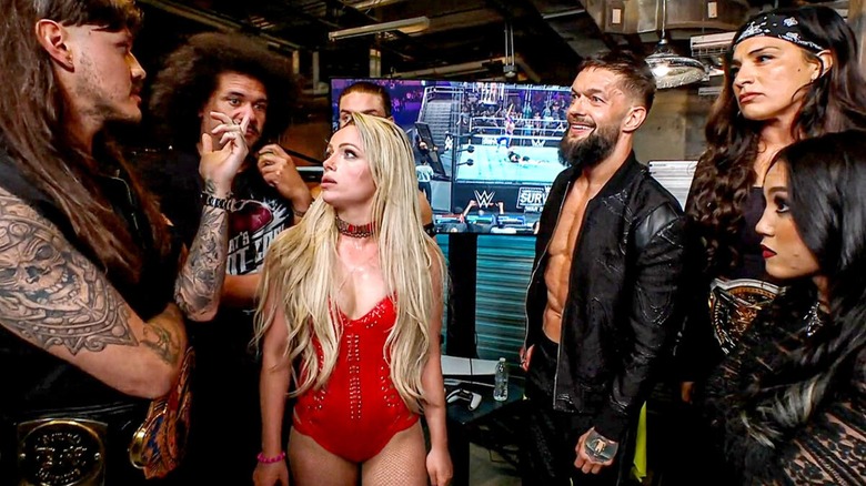 The Judgment Day (Dominik Mysterio, Carlito, Liv Morgan, JD McDonagh [obscured], Finn Balor, Raquel Gonzalez, and Roxanne Perez) during a backstage segment.