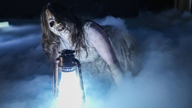 With a haunting gaze in her eye, Nikki Cross crawls out to the entrance lamp with Bray Wyatt's signature lantern