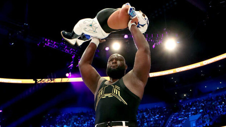 Omos holding Microman up high