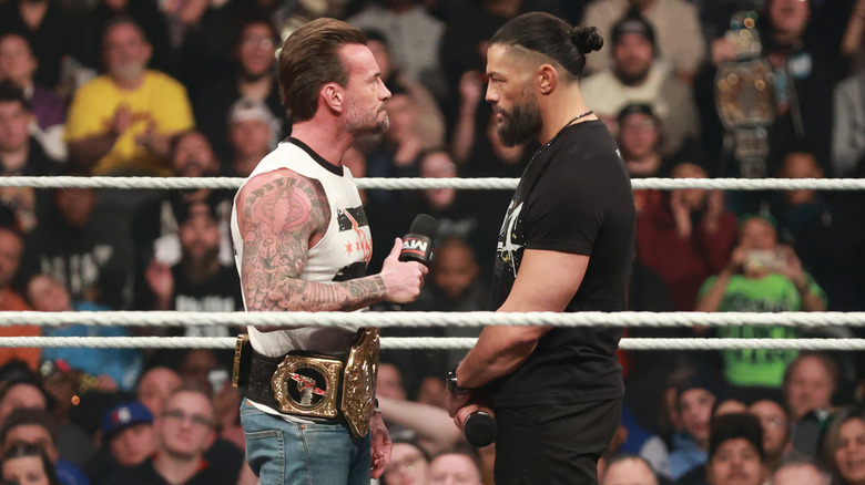 CM Punk and Roman Reigns face off in the ring