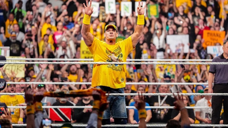 John Cena poses for the audience in the ring before a match at WWE Crown Jewel.