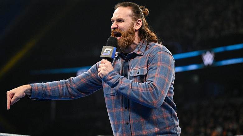 Sami Zayn wearing a blue flannel shirt on WWE SmackDown