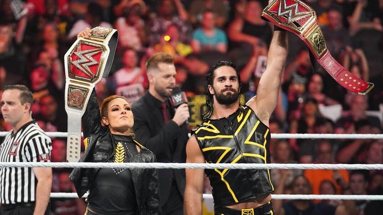Former WWE Raw Women's Champion Becky Lynch and former WWE Universal Champion Seth Rollins hold their titles high before facing Lacey Evans and Baron Corbin at WWE Extreme Rules in 2019