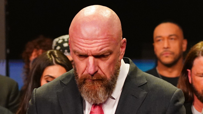 Triple H looking down, so no one notices he's complicit