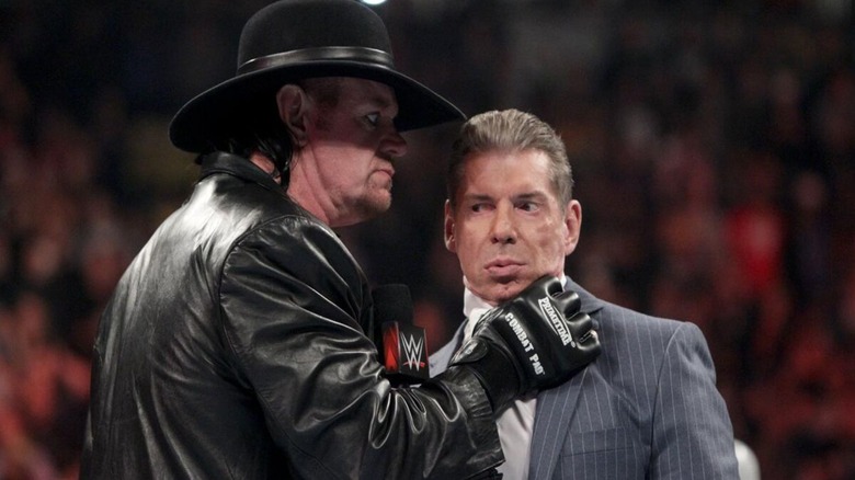 The Undertaker puts his hand around the throat of Vince McMahon's 