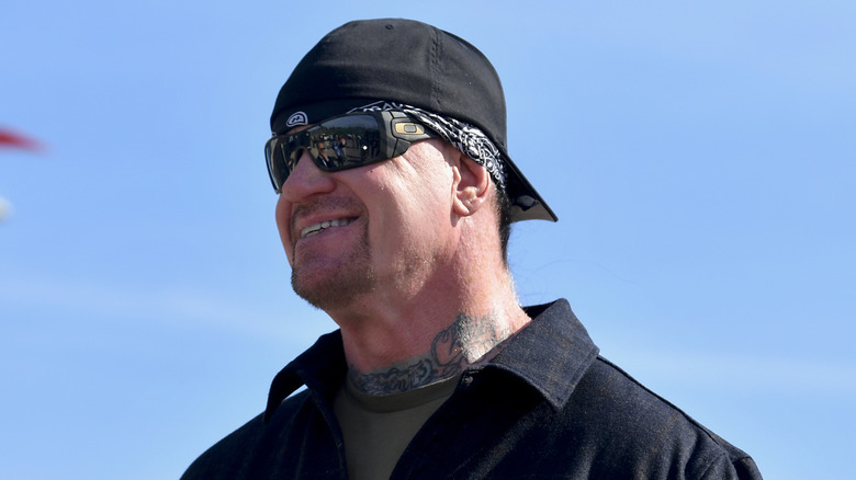 The Undertaker posse for a photo prior to his pace car practice ride for the NASCAR Cup Series Echopark Automotive Grand Prix