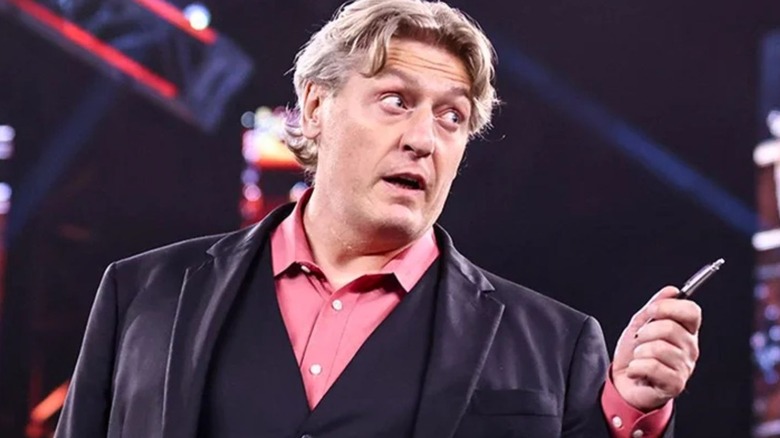 William Regal holding a pen