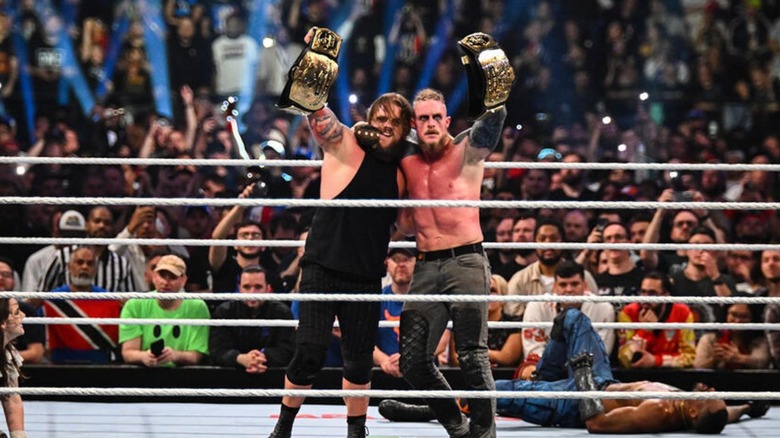Joe Gacy and Dexter Lumis hold up their WWE Tag Team Championships after a successful defense against The Street Profits at Clash in Paris.