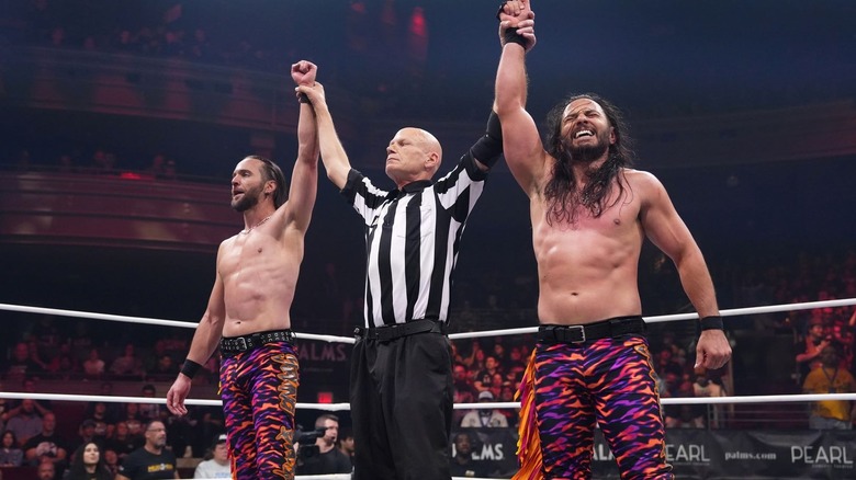 The Young Bucks have their hands raised